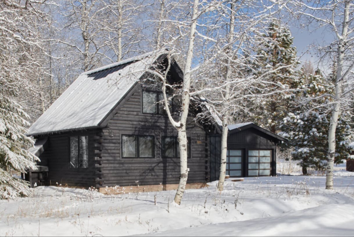 1970s renovated log cabin featuring cozy cabin design principles in winter setting