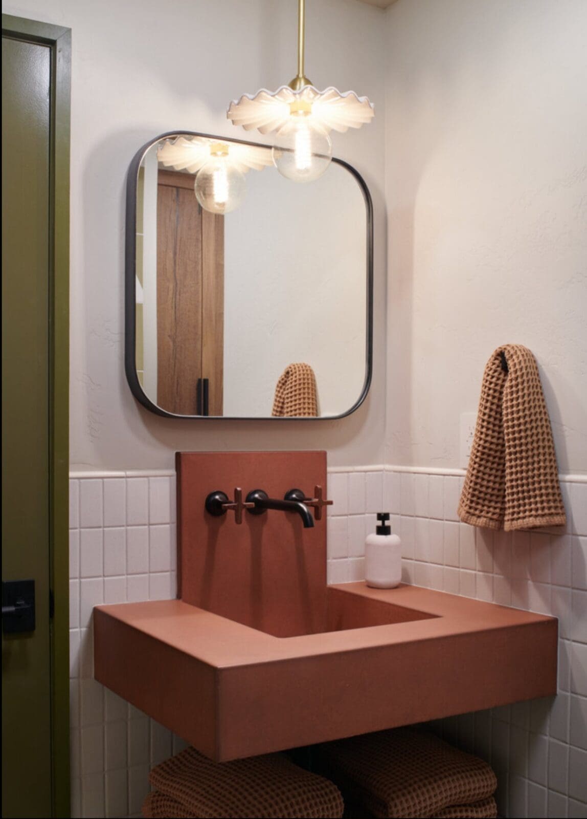 Custom copper vanity with modern fixtures and waffle weave towels in cabin bathroom