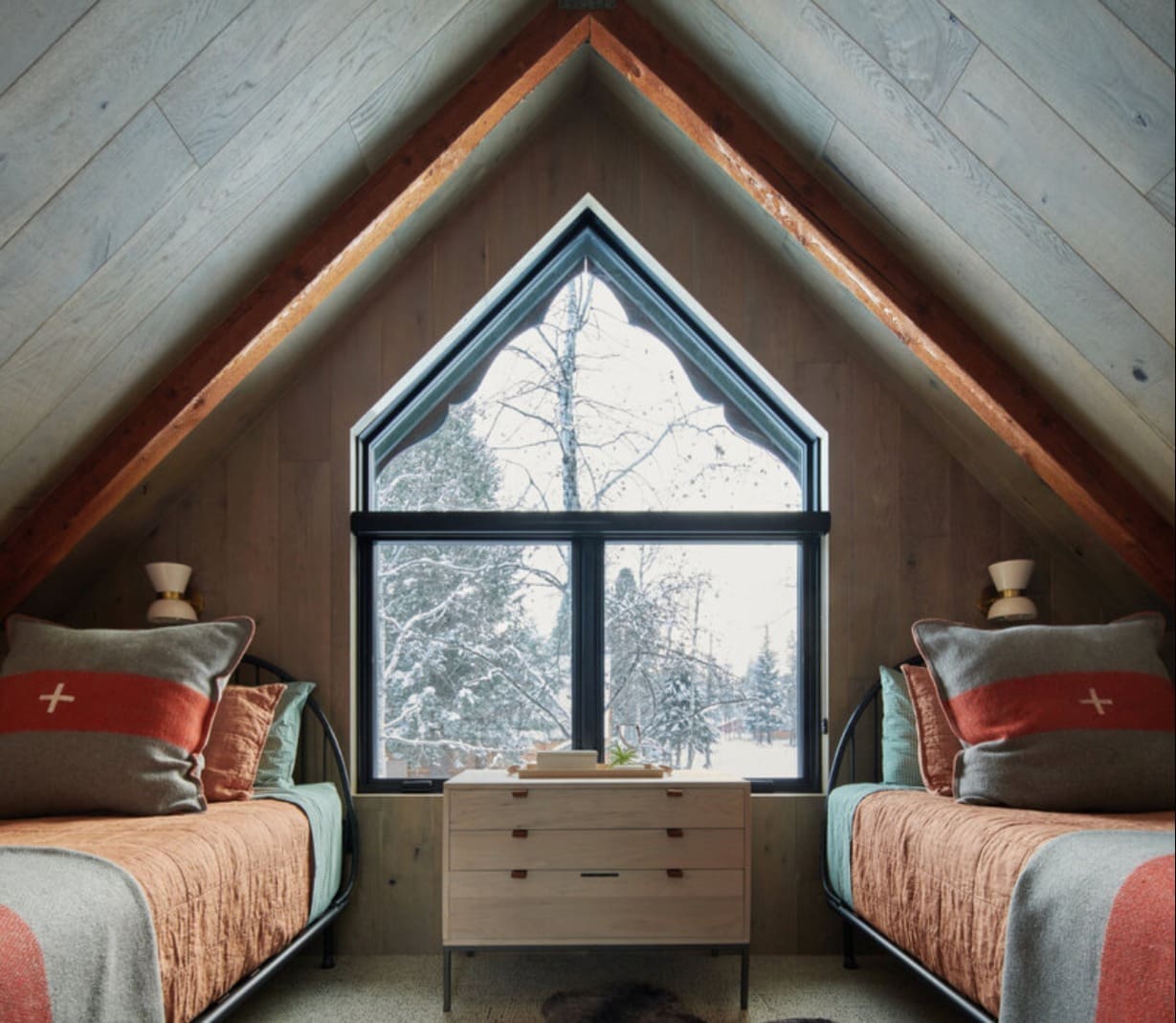Swiss flag pillows accent upstairs bedroom with vaulted ceilings in McCall mountain cabin