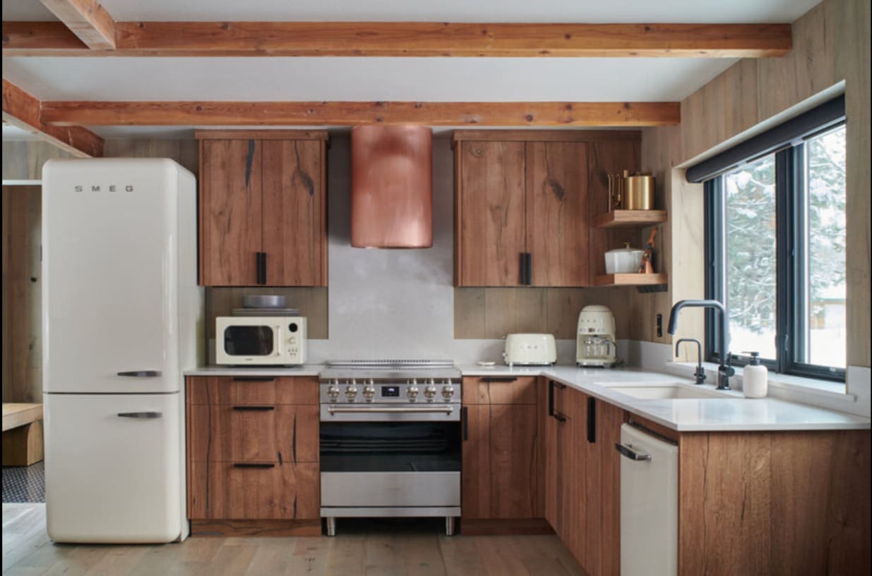 "Custom copper hood and walnut cabinetry in McCall cabin kitchen designed by Lewis & Co