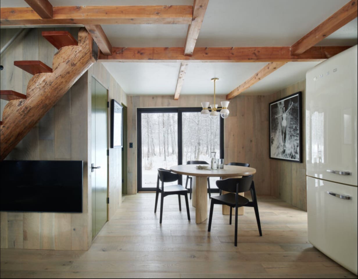 Open floor plan dining area with narrow log staircase in 800 square foot McCall cabin